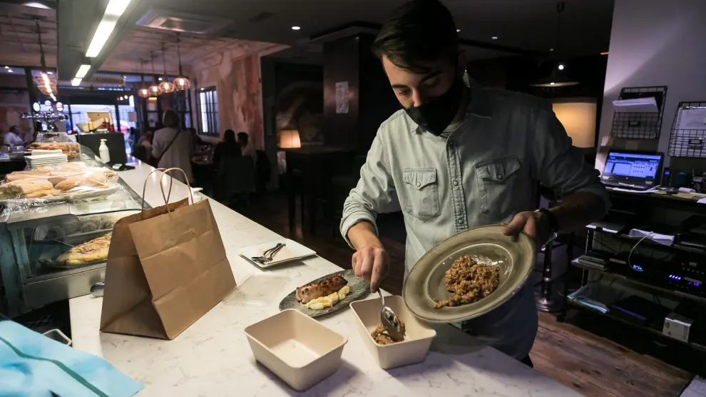Un trabajador del restaurante La Bocca envasaba ayer los excedentes de una paella.