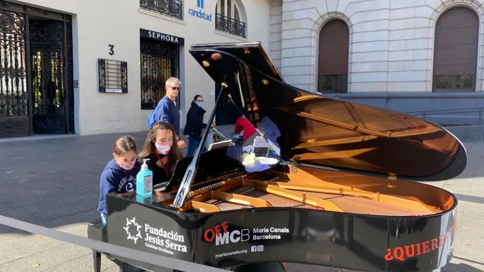 Dos niñas tocando en el piano colocado en la plaza de España