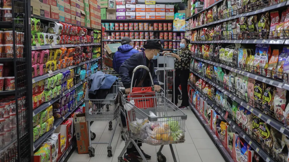 People shop in supermarket as China urges families to keep stocks of daily necessities ahead of winter