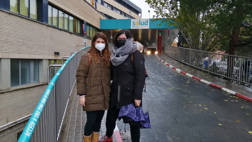 Ana María Pelleja, enfermera, y Amparo Bozán, auxiliar, en la entrada al Hospital Clínico de Zaragoza, donde trabajaron juntas 18 meses de pandemia.