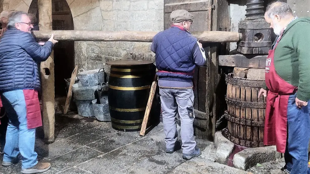 Demostración del funcionamiento de una antigua prensa de vino.