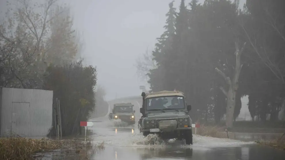 Dos vehículos militares, este lunes, en la carretera de acceso a Alfocea por Monzalbarba cortada por la crecida.