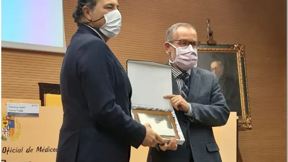 José Antonio Palau (izda.) recibe la placa de manos del presidente del Colegio de Médicos de Zaragoza, el doctor Javier García Tirado.