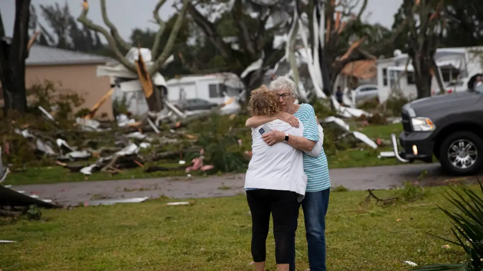 Residents of Century 21 in the Iona area embrace after a tornado touched down in Fort Myers