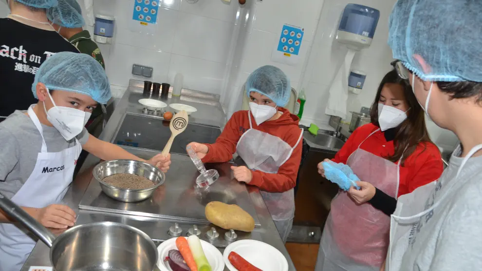 Marcos, Dani, la voluntaria Cristina Morón y Guille, en la cocina de Azafrán.