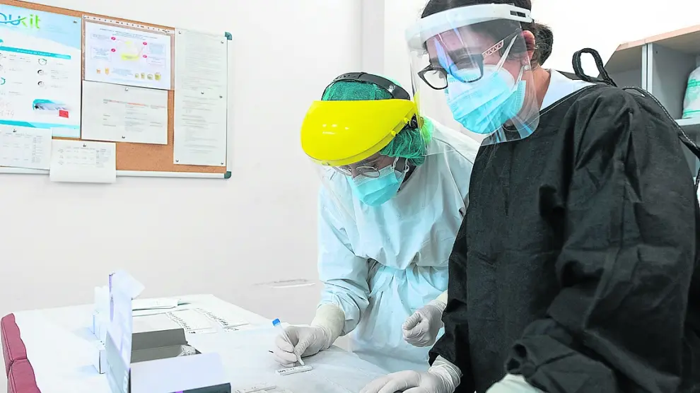 Dos enfermeras comprueban el resultado de un test de antígenos en el centro de Valdespartera.