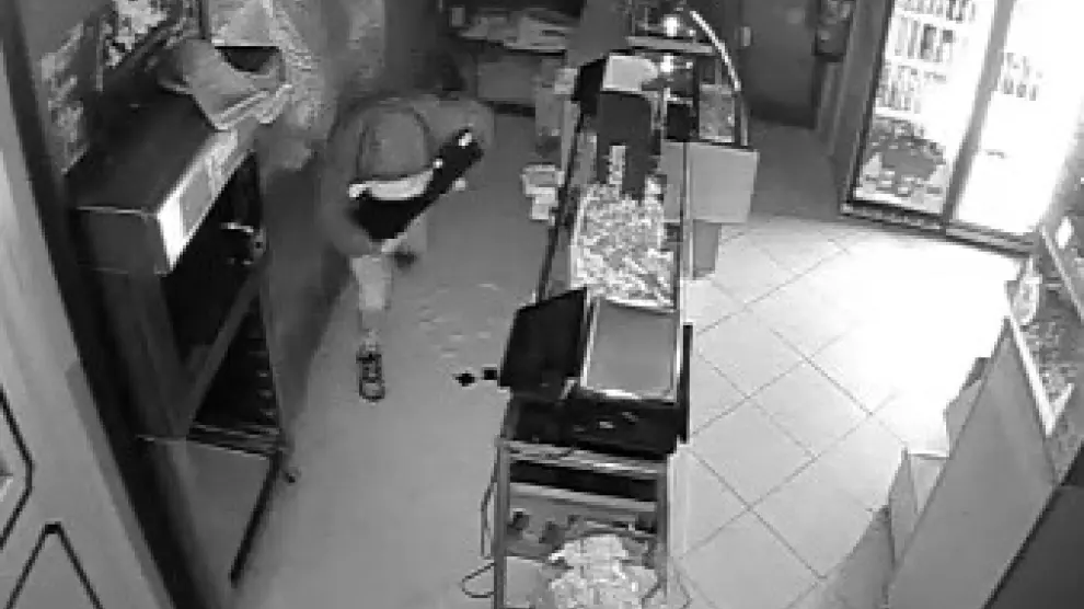 Uno de los detenidos por cometer robos en tiendas de frutos secos de Zaragoza, en plena acción en una imagen grabada por videocámara.
