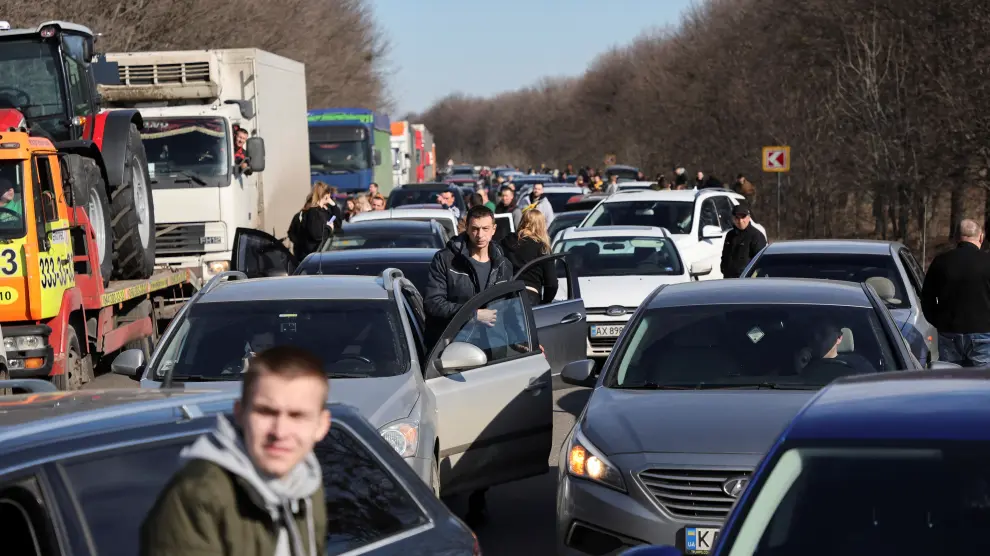 People wait in a traffic jam as they leave the city of Kharkiv