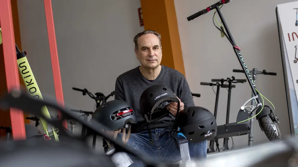 Juan Pérez, propietario de Eco Rider Shop, muestra varios modelos de cascos para patinetes.