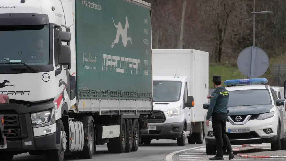 Un agente de la Guardia Civil dirige el tráfico de camiones en Lugo, durante el cuarto día de paros en el sector de los transportes.