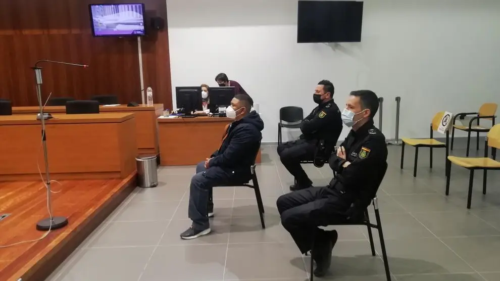 El acusado, escoltado por dos policías, durante el juicio celebrado en la Audiencia de Zaragoza.