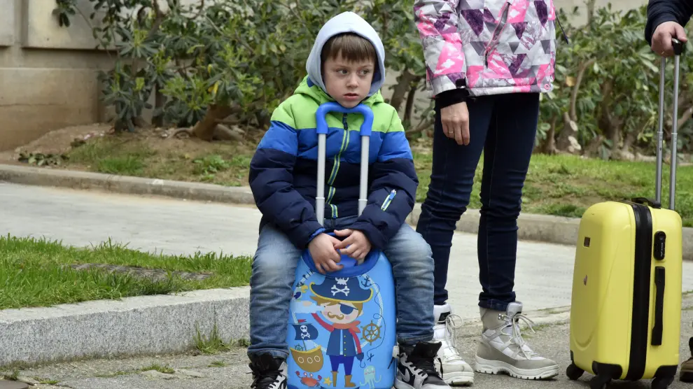 Un niño refugiado descansa sobre su maleta tras llegar a España.