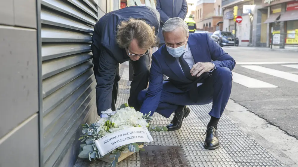 El presidente del PP de Aragón, Jorge Azcón, y Manuel Giménez Larraz, hijo del presidente del PP asesinado por ETA Manuel Giménez Abad, colocan un ramo de flores en el lugar donde la banda terrorista acabó con su vida en 2001.