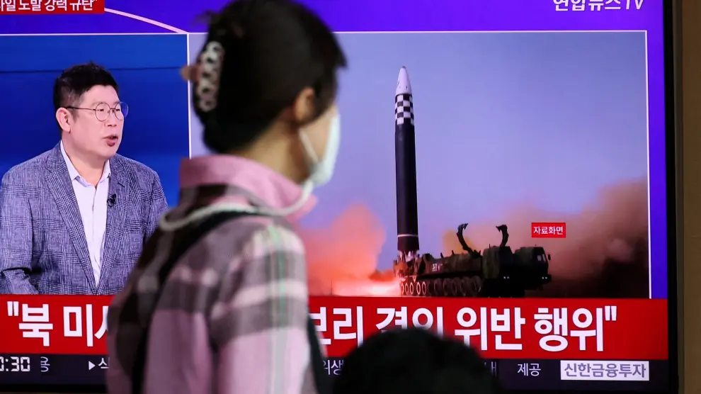 Una persona mira un televisor que informa sobre el lanzamiento de tres misiles por parte de Corea del Norte, en Seúl.