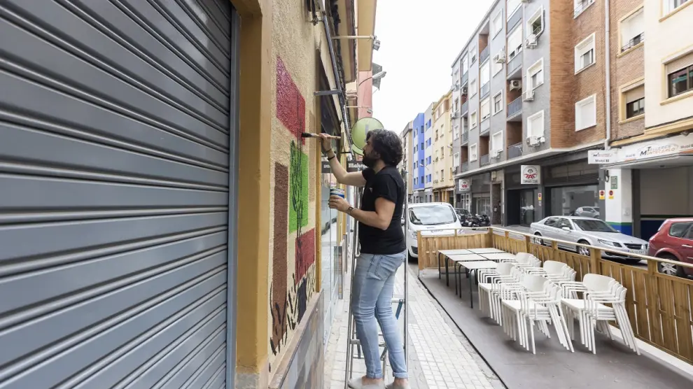 Mauro Albero, el pasado jueves, pintando la fachada del Bravo Café.