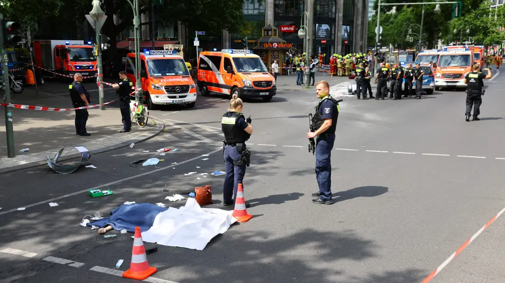 Berlin (Germany), 08/06/2022.- Police officers cover the body of a person after a car drove into a crowd of people in central Berlin, Germany, 08 June 2022. According to police, a man is said to have driven into a group of people in central Berlin. One person died and several others were injured in the accident. (Alemania) EFE/EPA/FILIP SINGER GERMANY BERLIN CAR PLOWS INTO CROWD