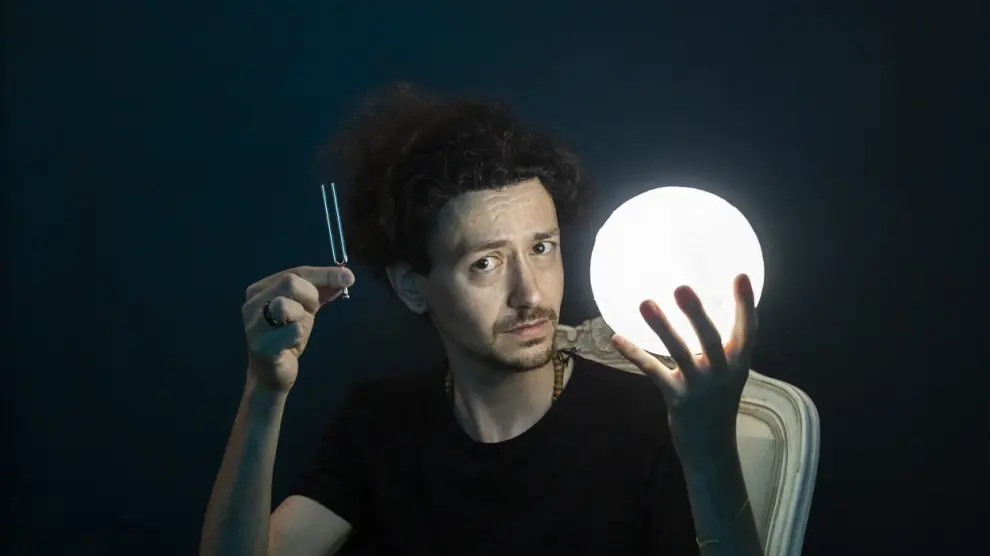 El investigador zaragozano Carlos Traginer, con la Luna en una mano y un diapasón en la otra.