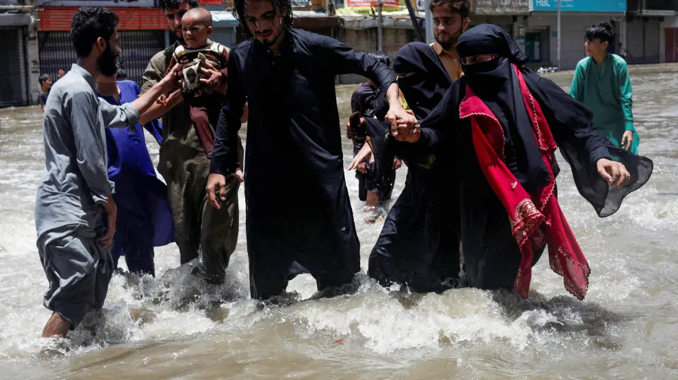 Una familia intenta avanzar en una calle inundada de Karachi.
