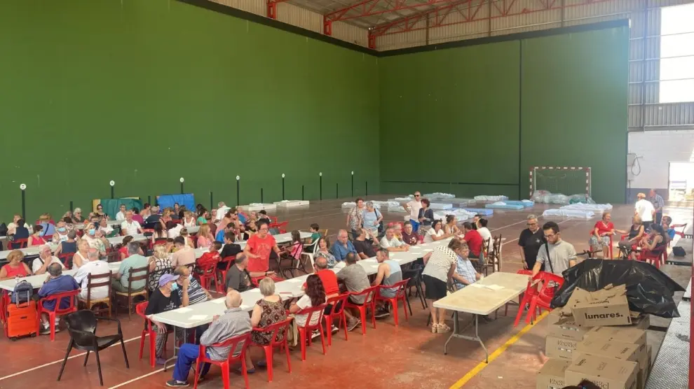 Los vecinos y turistas recogidos ayer en Alhama de Aragón comen esta mañana una paella en el pabellón de Nuévalos, donde los acogieron ancohe en los hoteles y las casas rurales.