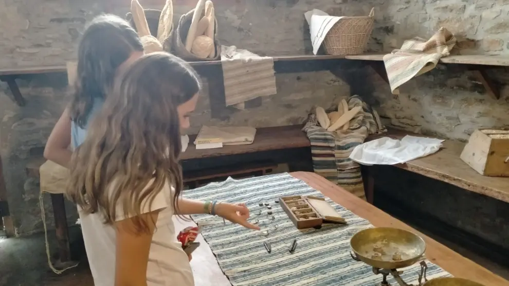 Dos niñas observan los instrumentos que se utilizaban en la elaboración del pan.