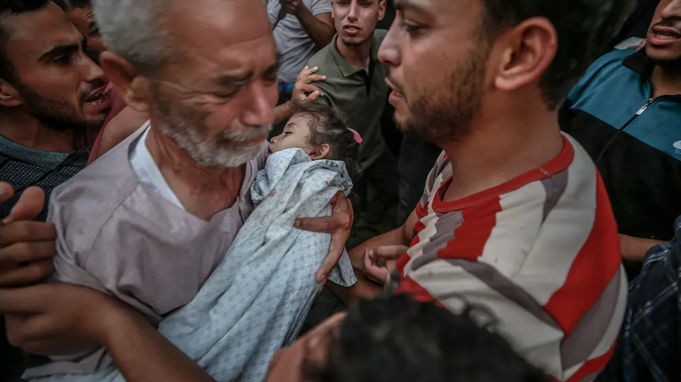El abuelo de la niña Alaa Qadoum sostiene el cuerpo de la niña durante su funeral en Gaza.