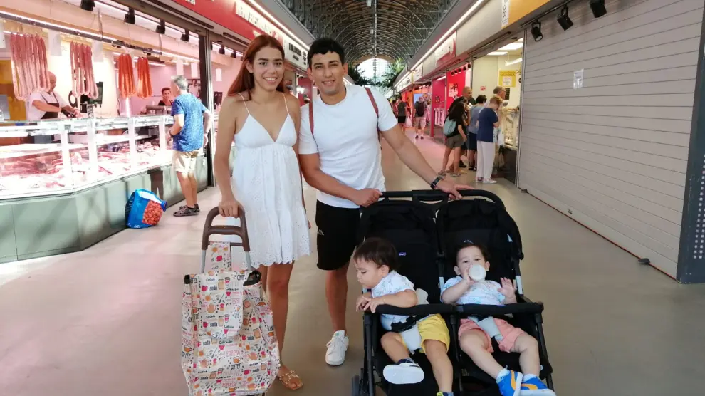 Isabel Aguirre y Arnoldo Gríos, pareja con sus dos hijos de compras en el Mercado Central de Zaragoza.