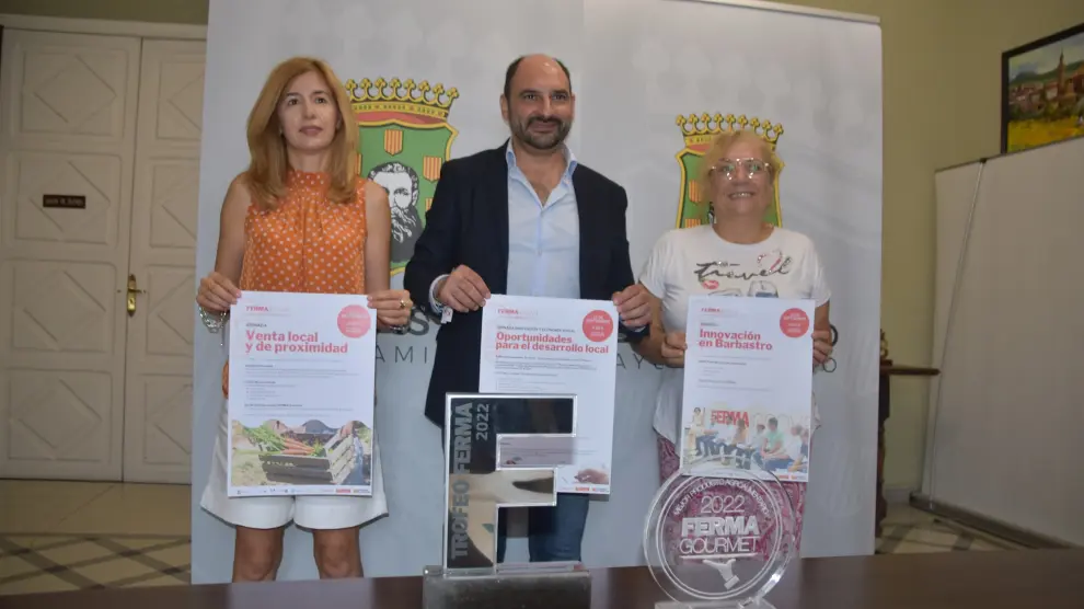 La concejal Belinda Pallás, el alcalde Fernando Torres y Asun Berroy de AMEPHU con el cartel de la triple jornada de FERMA Innova.