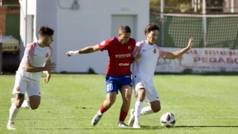 Carbonell disputando un balón con un jugador del Mallorca B.