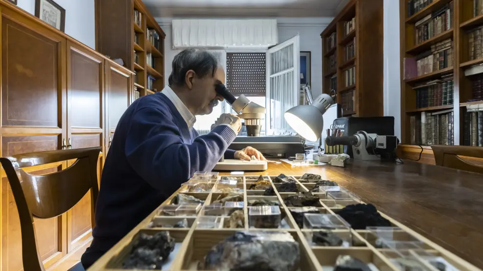 Miguel Calvo Rebollar estudia uno de los ejemplares que componen su colección de minerales