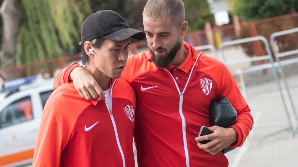 Jorge Pulido habla con Kento en la llegada de la SD Huesca a Anduva.
