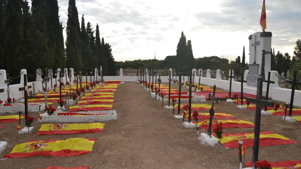 Las tumbas de militares aragoneses fallecidos en los años 40 y 50, enterrados en el cementerio de Torrero, son galardonados con banderas de España.