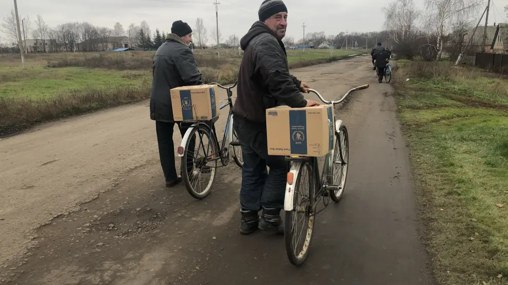 Dos hombres utilizan sus bicicletas para transportar la ayuda humanitaria recibida