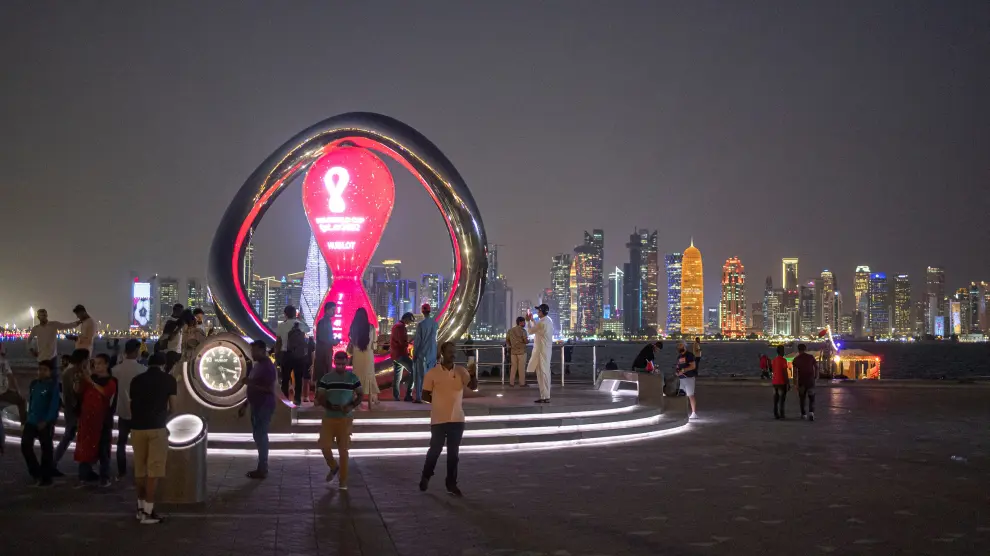 Varios ciudadanos en Doha ante una escultura conmemorativa del Mundial