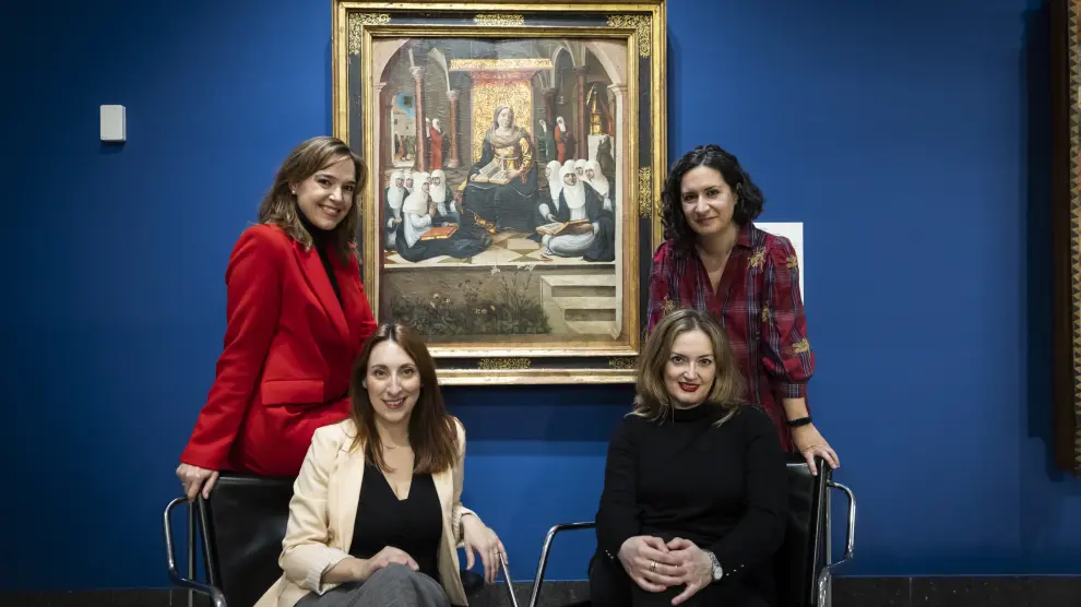 Ana Morte y Laura Malo (a la izquierda) y Rebeca Carretero y María Ángeles Montanel (a la derecha) flanquean el cuadro ‘La Escuela de las Vírgenes’, en el Museo de Zaragoza.