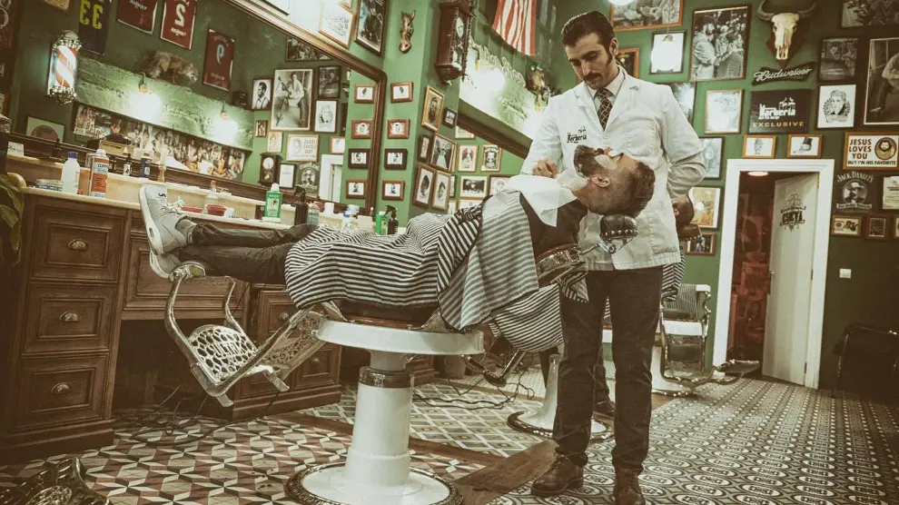 Jorge Villaroya, en la barbería Tío Jorge, atendiendo a un cliente.