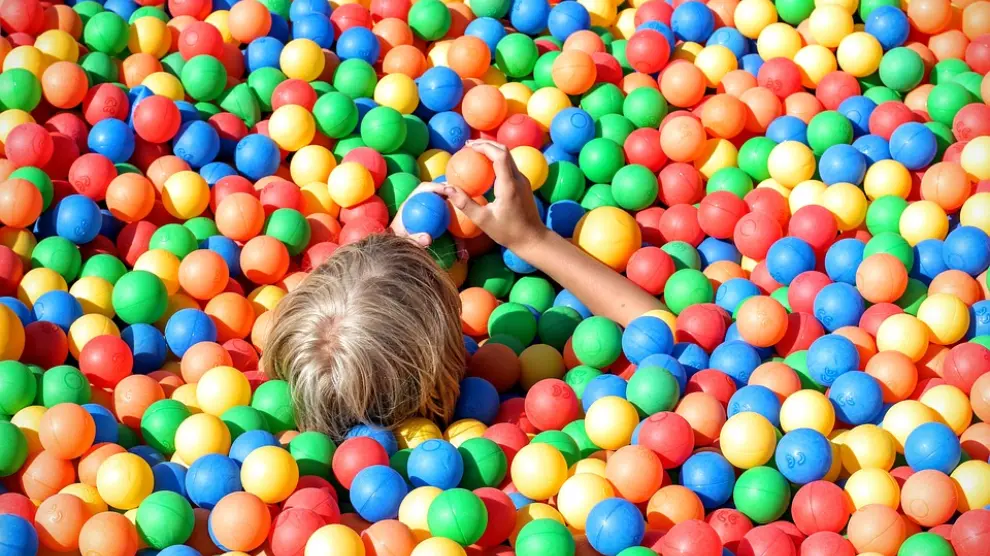 Foto de archivo de un niño en una piscina de bolas