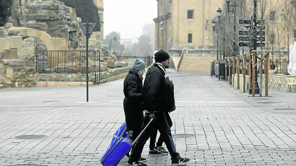 Varios turistas, ayer, con sus maletas por el centro de Zaragoza