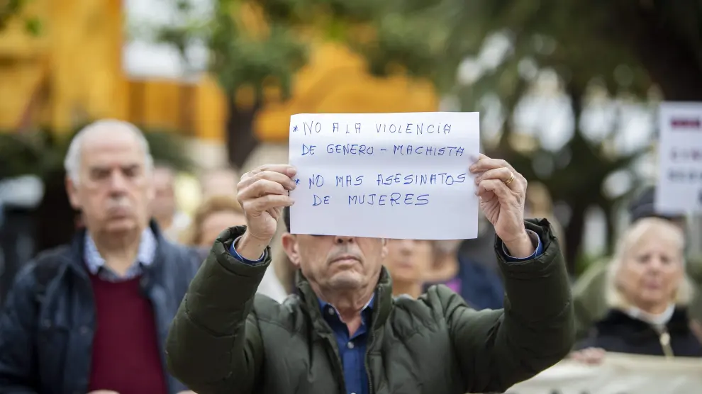 Un hombre muestra un cartel durante la concentración realizada este lunes a las puertas del Ayuntamiento de El Puerto de Santa María (Cádiz) en repulsa por el asesinato de una mujer de 46 años a manos de su pareja, un hombre que ha sido detenido.