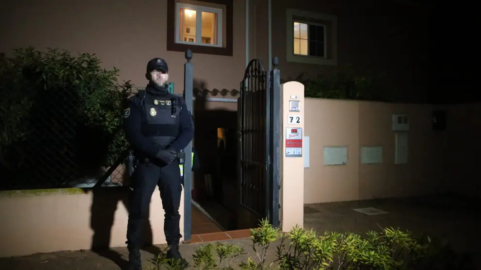 Un policía custodia el edificio donde se han hallado los cadáveres de la pareja en La Línea, Cádiz.
