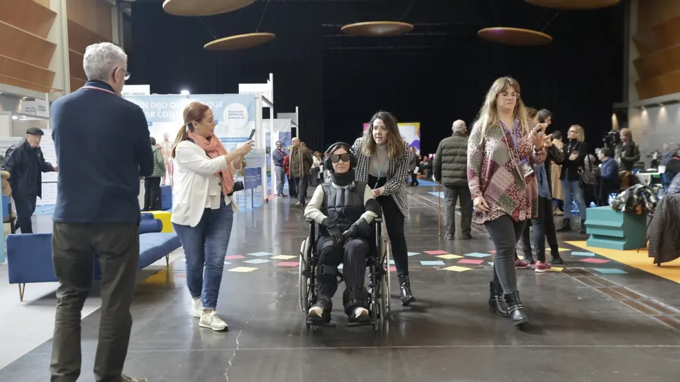 Eva Caballero va en silla de ruedas con los elementos que le permiten meterse en la piel de una persona mayor con limitaciones físicas y sensoriales