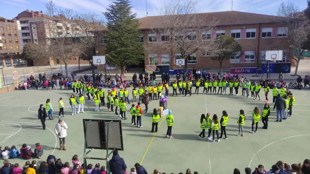 Los alumnos del colegio Pedro J. Rubio de Huesca dibujan un lazo contra el cáncer infantil.