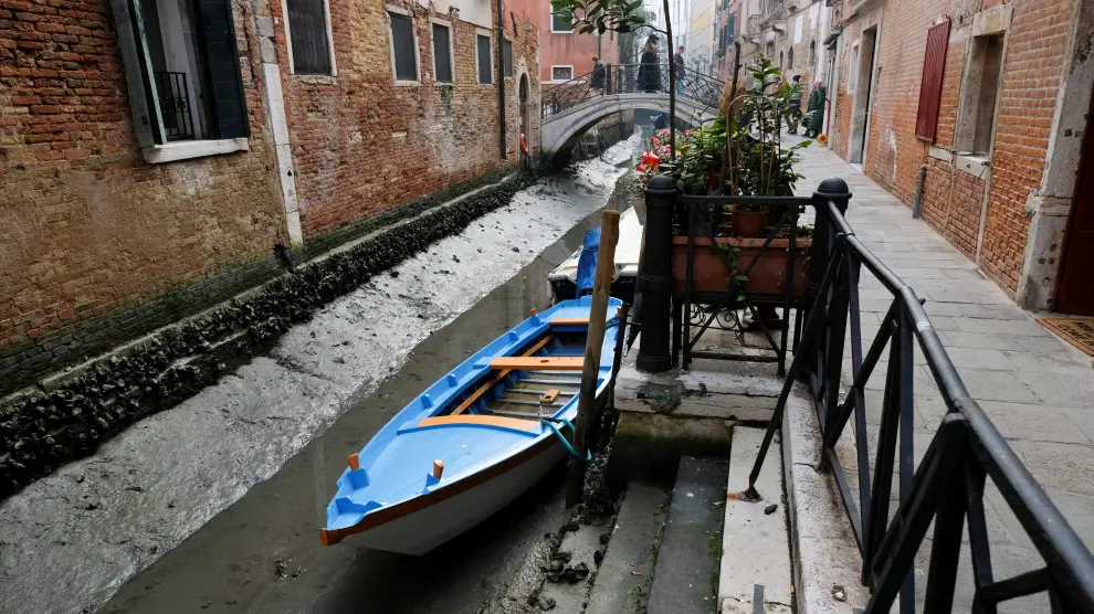 Boats are pictured in a canal during a severe low tide in the lagoon city of Venice, Italy, February 17, 202. REUTERS/Manuel Silvestri EUROPE-WEATHER/ITALY-DROUGHT