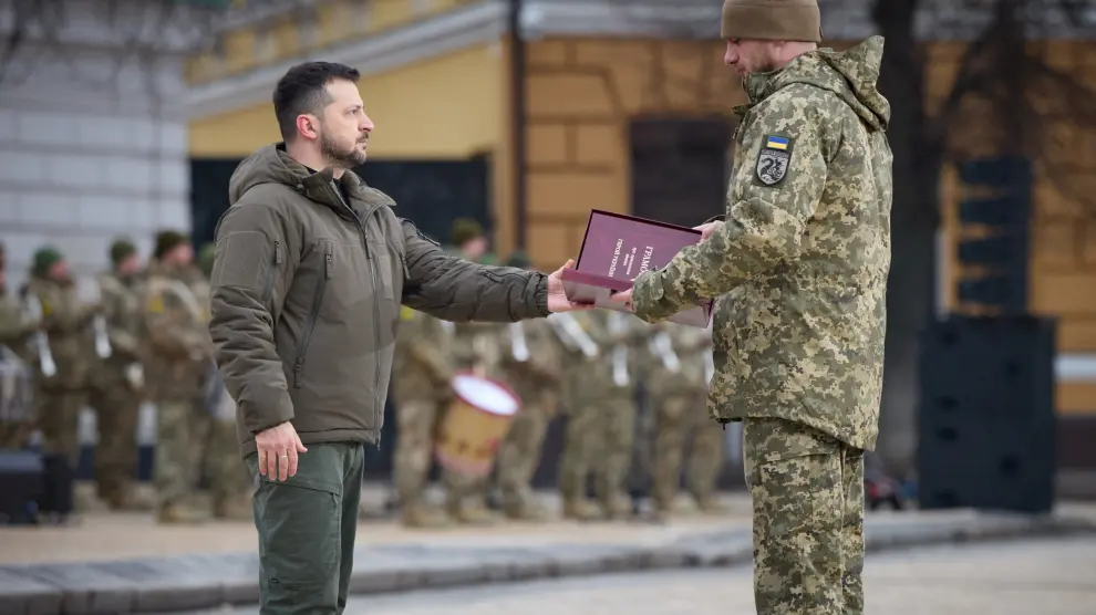 Ukraine's President Volodymyr Zelenskiy handovers a flag to a serviceman during a ceremony dedicated to the first anniversary of the Russian invasion of Ukraine, amid Russia's attack on Ukraine, in Kyiv, Ukraine February 24, 2023. Ukrainian Presidential Press Service/Handout via REUTERS ATTENTION EDITORS - THIS IMAGE HAS BEEN SUPPLIED BY A THIRD PARTY. UKRAINE-CRISIS/ANNIVERSARY-CEREMONY