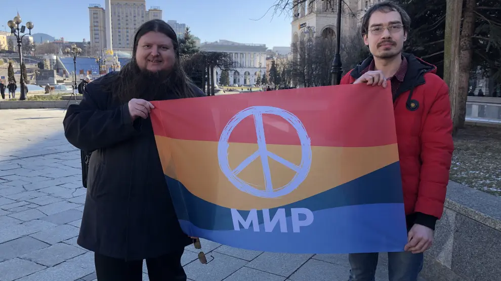 Yuri Scheliazhenko, a la izquierda y Serhii Ustymenki muestran una bandera del Movimiento Pacifista e Ucrania en el centro de Kiev.