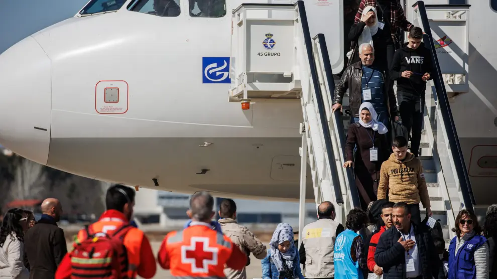 Un grupo de refugiados sirios provenientes de Turquía y afectados por el terremoto bajan del avión en la base aérea de Torrejón de Ardoz