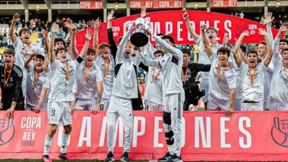 Cucalón, a la izquierda de la copa, levanta el trofeo conquistado por el Real Madrid.