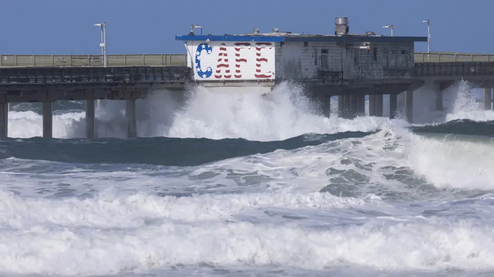 Olas chocan contra un muelle del océano en la costa de San Diego, California