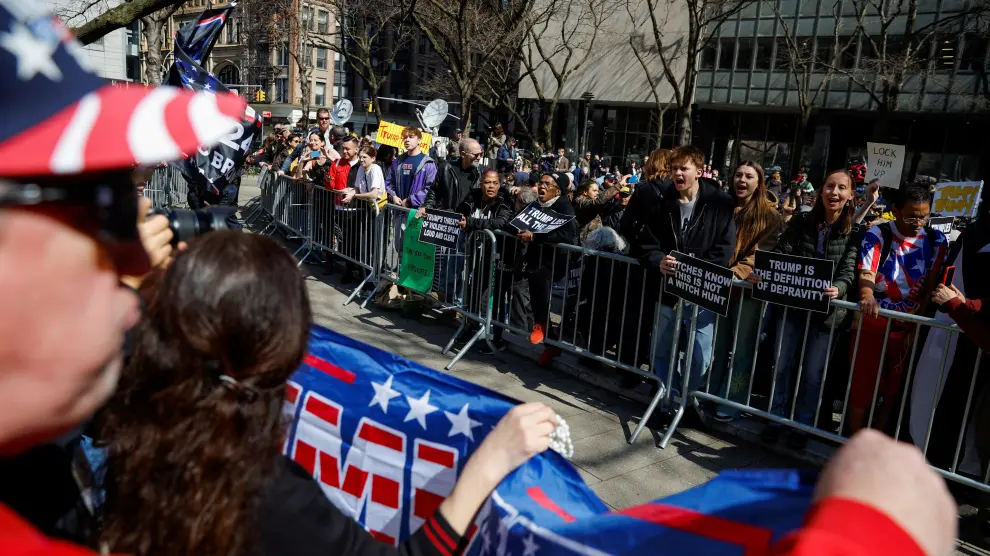 A flag in support of  former U.S. President Donald Trump is waved outside Manhattan Criminal Courthouse on the day of his planned court appearance after his indictment by a Manhattan grand jury following a probe into hush money paid to porn star Stormy Daniels, in New York City, U.S., April 4, 2023. REUTERS/Amanda Perobelli USA-TRUMP/