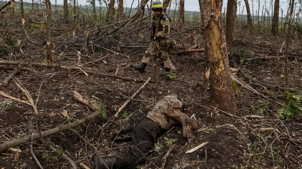 Un soldado ucraniano mira el cadáver de uno ruso cerca de Bakhmut