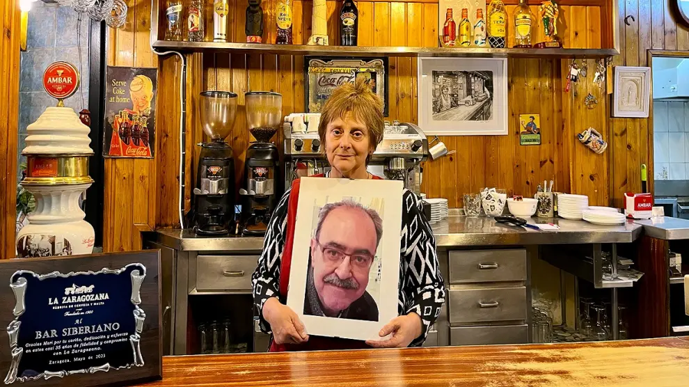 Mari García Pardos, tras la barra del Siberiano, con una foto de su esposo.